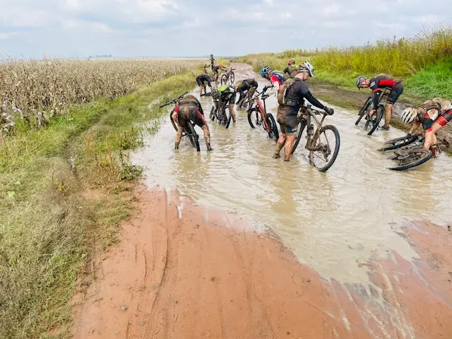 Mountainbiker kämpfen sich durch knietiefen Schlamm — Königsetappe Tag 3 der Joberg2C 2022 Südafrika