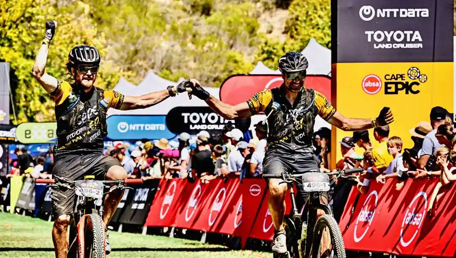 Killertaler Herren MTB-Team bei der Zieleinfahrt Grand Finale Absa Cape Epic 2026 in Stellenbosch — in Killertaler Herren Radtrikots nach 8 Etappen durch Südafrika